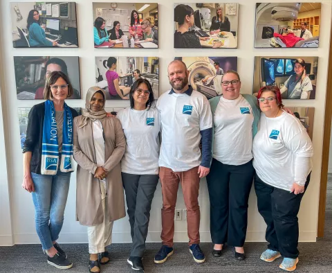 Six smiling people wearing HSA t-shirts and scarves.