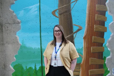 A picture of Lisa Daechsel standing in front of a painted wall. 