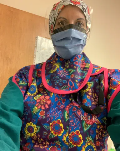 A selfie of Rosey Manhas, HSA member. She is wearing protective equipment such as a mask.