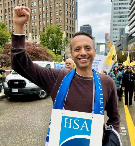 An image of a man smiling with his fist in the air. 
