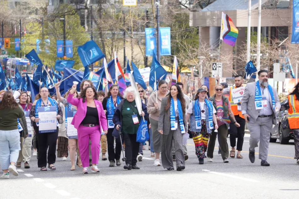 A group of HSA members marching with signs and flags.